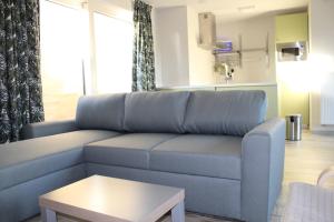 德帕内De Panne - Adinkerke - 't Voetbrugsje comfortabele nieuwbouw的客厅配有蓝色的沙发和桌子