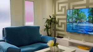 阿利坎特Spacious Modern Family Apartment - Centre & Near Beach的客厅配有蓝色椅子和平面电视