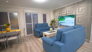 阿利坎特Spacious Modern Family Apartment - Centre & Near Beach的客厅配有2把蓝色椅子和电视