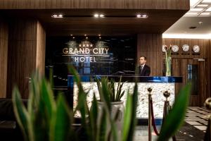 弗罗茨瓦夫Hotel Grand City Wrocław的站在大城市酒店讲台上的人