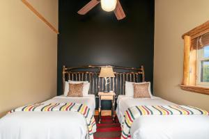 North CreekThe Alpine Lodge的配有黑色墙壁的客房内的两张床