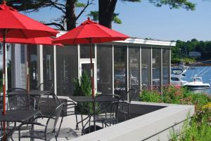 约克码头游客区酒店的一个带桌椅和红伞的庭院