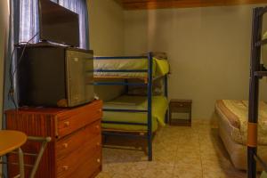圣佩德罗·德·阿塔卡马La Casa del Sol Naciente的一间卧室配有一张双层床和带电视的梳妆台。