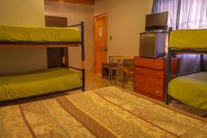 圣佩德罗·德·阿塔卡马La Casa del Sol Naciente的客房设有两张双层床和电视。