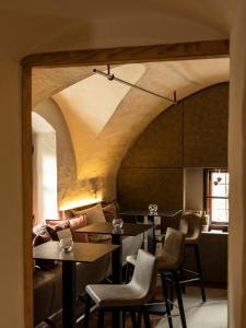 毛特恩多夫Mesnerhaus & Gourmetrestaurant Mesnerhaus mit 4 Hauben的一间带桌椅和天花板的餐厅