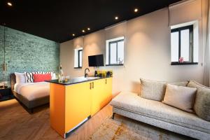 特拉维夫Silicate Ben Yehuda - Smart Hotel by Loginn Tel Aviv的带沙发、水槽和床的客房