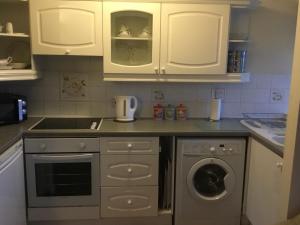 刘易斯High View Retreat的厨房配有白色橱柜和洗衣机。