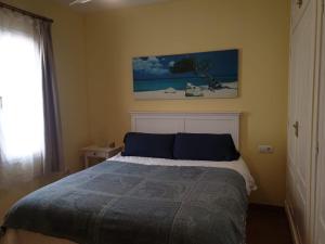 拉伊斯莱塔德尔摩洛Apartamento a 2 minutos andando a la playa.的卧室配有一张床,墙上挂有绘画作品