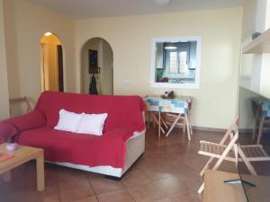 拉伊斯莱塔德尔摩洛Apartamento a 2 minutos andando a la playa.的客厅配有红色的沙发和桌子