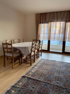 萨卡里亚Apartment at a Resort by the Black Sea的一间带桌椅和地毯的用餐室
