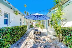 迈阿密Cottages El Portal的庭院配有两把椅子和一把遮阳伞