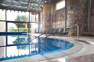 佩奇马卡运动及健身酒店的一座大型游泳池,位于一座带大窗户的建筑内