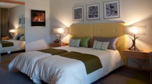 奥莱罗斯圣玛格丽达酒店 的一间卧室配有一张带两盏灯的大型白色床。