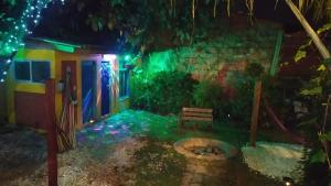 Carmen de ViboralHostal Macondo Inn的庭院里带绿灯的房子,带长凳
