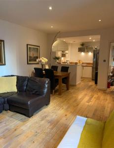 格拉斯哥Oswald Apartment - Glasgow City Centre的客厅以及带沙发和桌子的厨房。