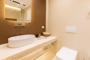 奥尔比亚Double A Luxury Room的浴室配有白色水槽和卫生间。