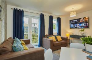 QueensburyBrackenhill Lodge Halifax的客厅配有沙发、椅子和电视