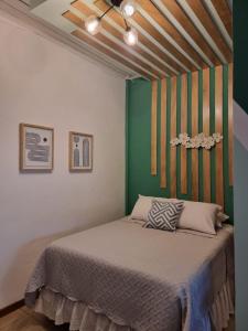 弗洛勒斯玛格丽塔宾馆的一间卧室配有一张带绿色墙壁的床
