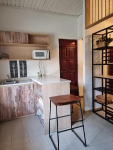 弗洛勒斯玛格丽塔宾馆的厨房配有柜台、水槽和凳子