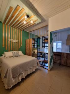 弗洛勒斯玛格丽塔宾馆的一间卧室设有一张床和绿色的墙壁