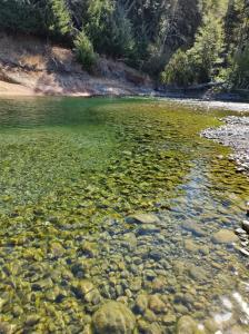 普埃洛湖Riberas del Azul的一大片水体,有岩石和树木
