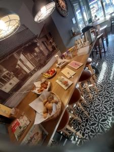梅赫伦Brasserie & Logies De Pijl的一张长木桌子,上面放着食物盘