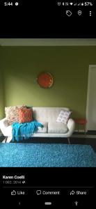 LeetonKindred Studio Apartments的客厅设有白色沙发,靠着绿色的墙壁