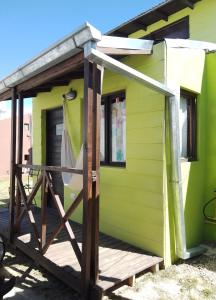 马德普拉塔卡瓦尼亚斯波多冲浪度假屋的绿色的小房子,设有木门廊