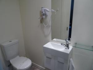 但尼丁Sahara Deluxe Studios的一间带卫生间、水槽和电话的浴室