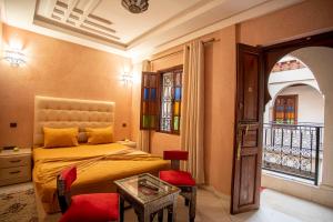 马拉喀什Riad Aymane的一间卧室配有一张床、一张桌子和一个窗户。