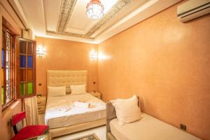 马拉喀什Riad Aymane的一间小房间,配有两张床和一张沙发