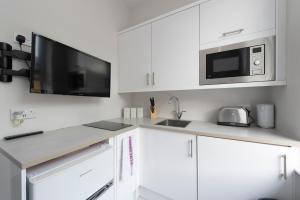 伦敦Fabulous Apartment in Superb location的厨房配有白色橱柜和微波炉
