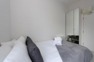 伦敦Fabulous Apartment in Superb location的卧室配有带枕头的白色床