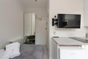 伦敦Fabulous Apartment in Superb location的一间白色的小房间,墙上配有电视