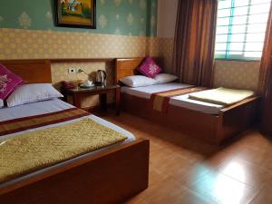 Bắc GiangKhách Sạn Hương Sơn的酒店客房设有两张床和窗户。