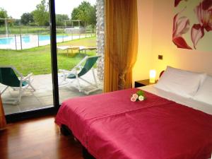 Marmirolo科尔特狂欢节农庄酒店的一间卧室配有一张床,享有游泳池的景色