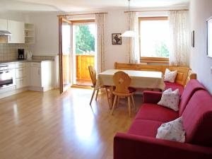 马兰扎Apartment Obermüllerhof-2 by Interhome的客厅配有红色的沙发和桌子