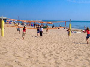 洛萨皮内塔Holiday Home Rosapineta Camping Village-1 by Interhome的一群人在沙滩上玩排球