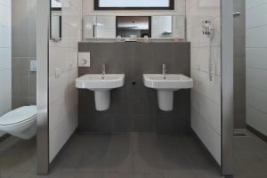 海尔许霍瓦德Hotel Babylon Heerhugowaard - Alkmaar的一间带两个盥洗盆和卫生间的浴室