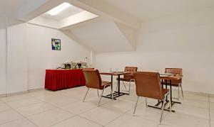 班加罗尔Treebo Trend Fortune Stay的用餐室配有椅子和一张桌子及红色的桌布