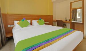 班加罗尔Treebo Trend Fortune Stay的一间卧室配有一张大白色的床和色彩缤纷的毯子