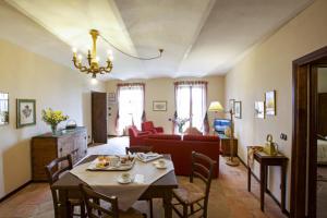 阿尔法诺纳塔Relais Castello di Razzano的客厅配有桌子和红色椅子