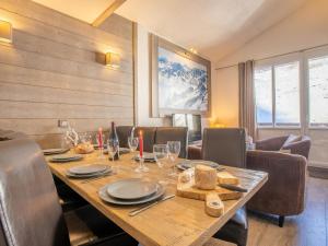 蒂涅Apartment Rond Point des Pistes - Val Claret-17 by Interhome的一间带木桌和椅子的用餐室