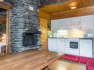 索特Holiday Home Vilkkuna 20 a by Interhome的厨房设有石制壁炉和木桌。
