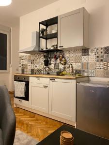 贝尔格莱德Apartment Major的厨房配有白色橱柜和炉灶烤箱。