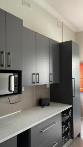 东伦敦Ikhwezi guest house的厨房配有黑白橱柜和微波炉
