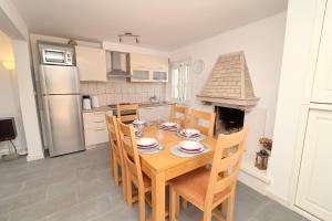 科尔丘拉Villa Ivana的厨房配有木桌、椅子和壁炉