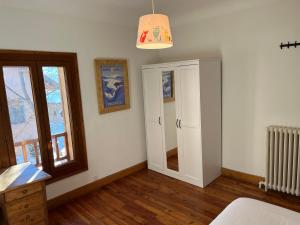 布里昂松Plein soleil的卧室设有白色的墙壁、窗户和镜子