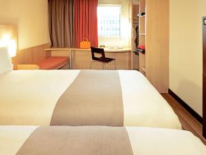 布拉加布拉加宜必思酒店的配有一张床和一把椅子的酒店客房