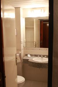 巴拉那Hotel Posta del Sol Paraná的一间带水槽、卫生间和镜子的浴室